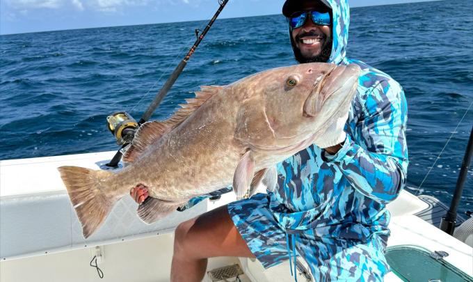 Angler holding a gag grouper caught on a fishing charter in Orange Beach
