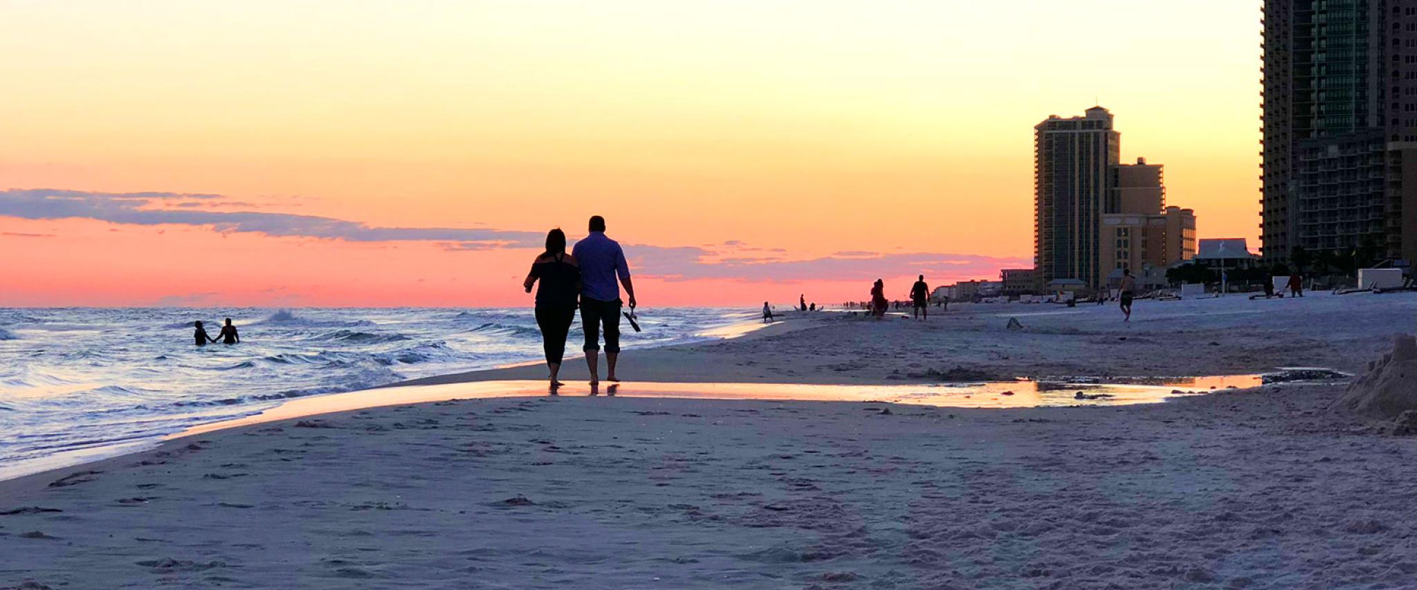 Couple walking in Orange Beach at Sunset