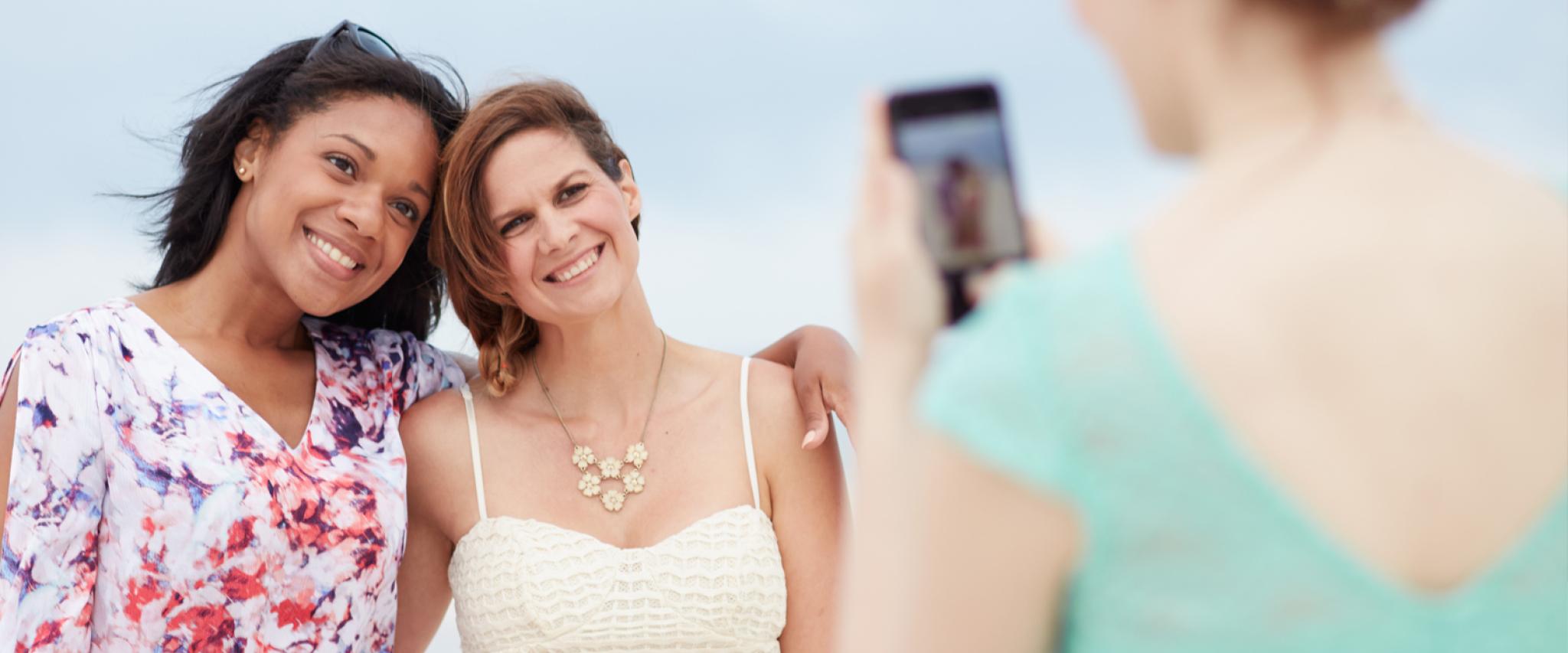 Girlfriends take photos on the beach