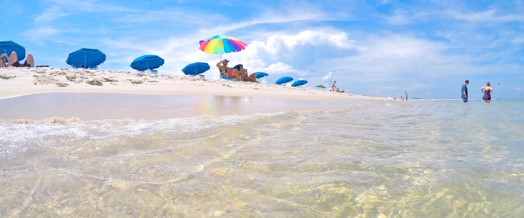 Clear surf and umbrellas along Alabama's White Sand Beaches