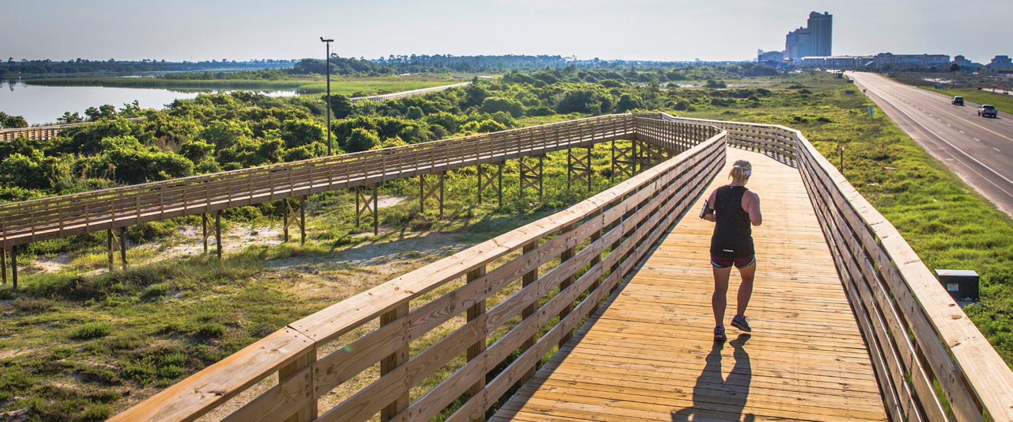 Woman Running on Boardwalk in Gulf Shores