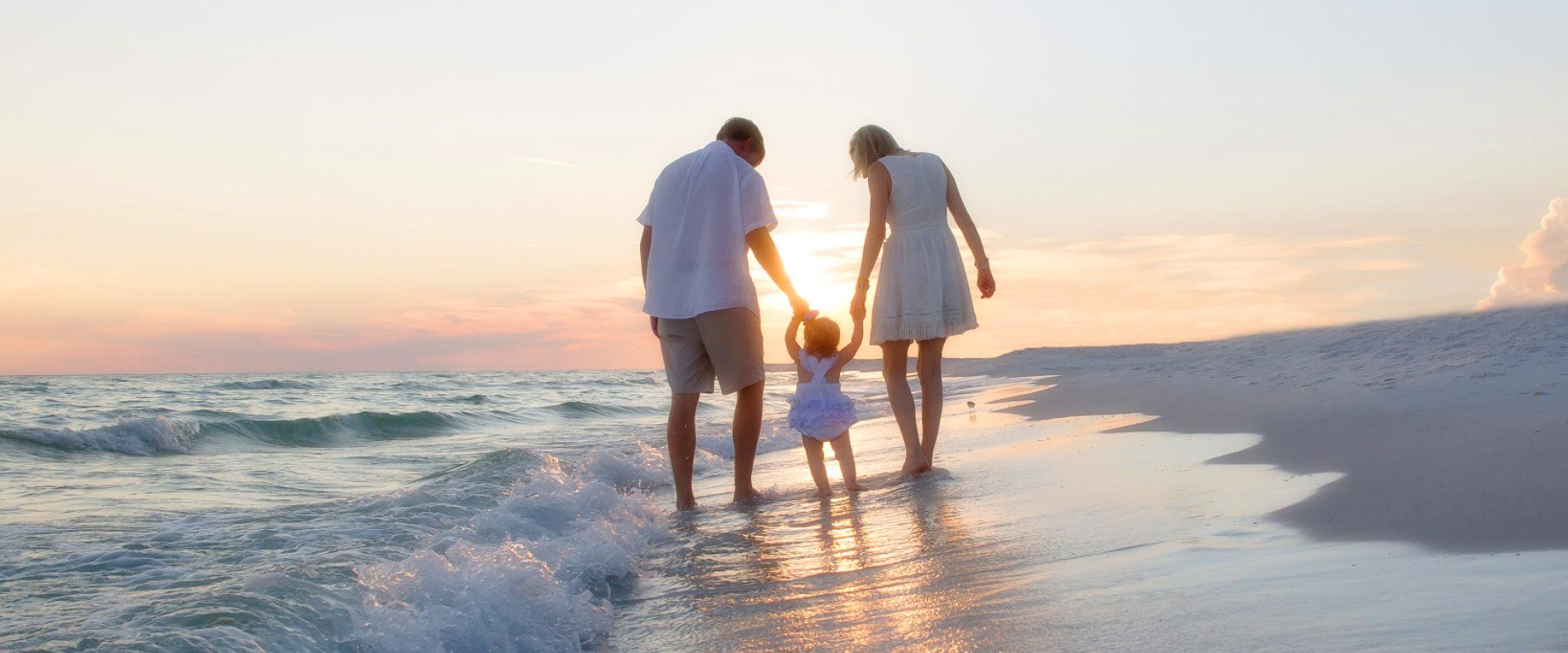 Family walking on Alabama's beaches at sunset