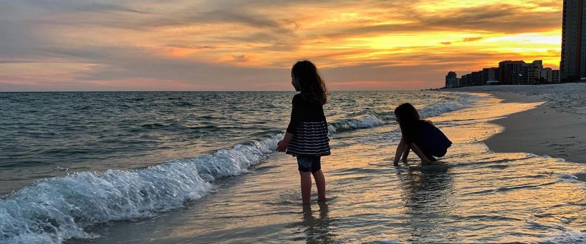 Sisters playing on the beach at sunset Orange Beach, AL