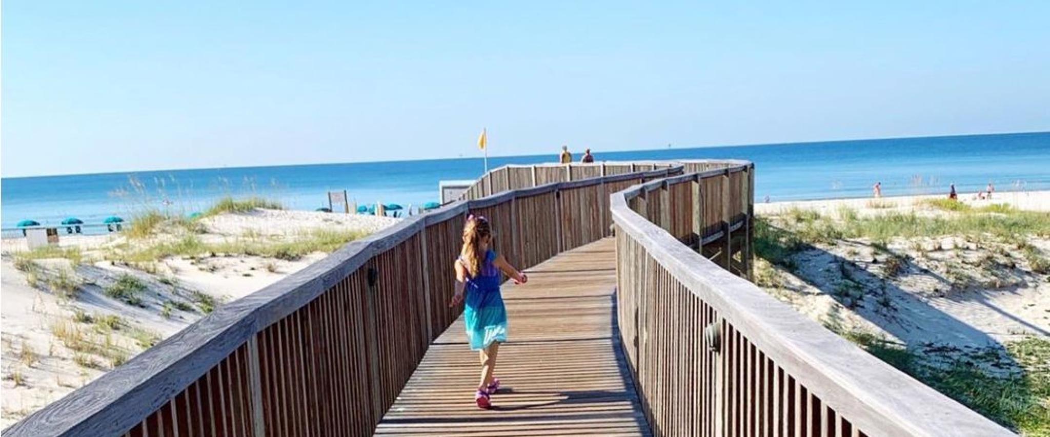 Little girl running out to the beach in Gulf Shores, AL