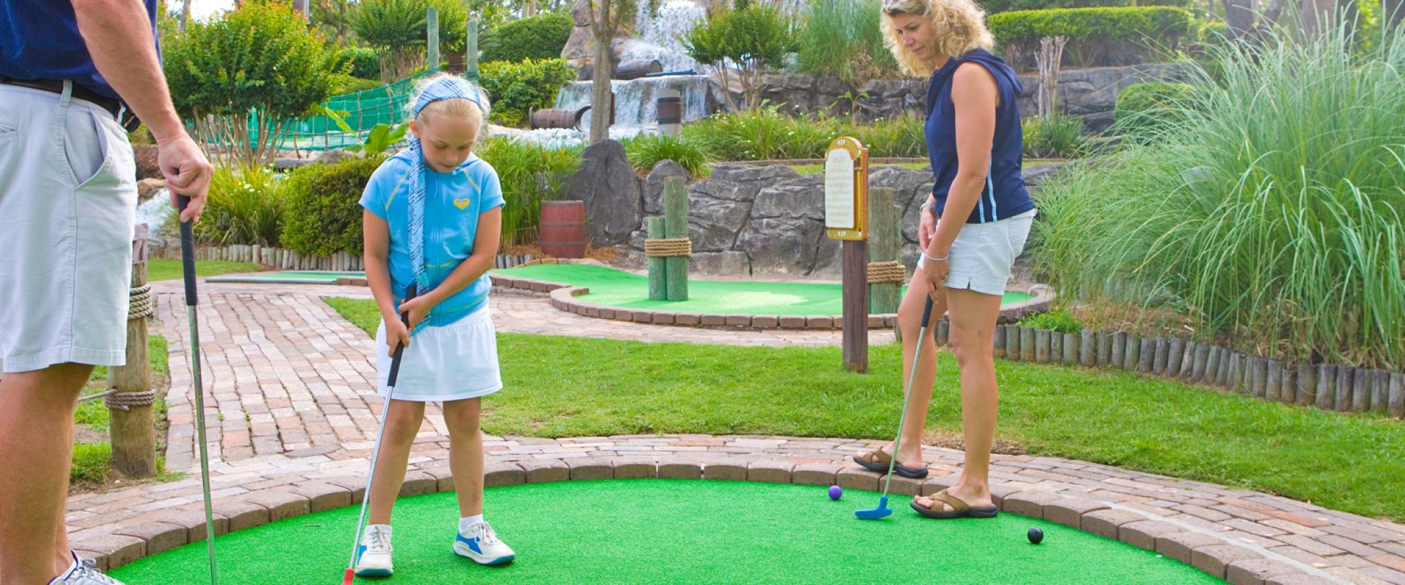 Family playing mini golf