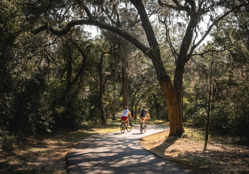 Couple biking along the paved trails in Gulf State Park in Orange Beach