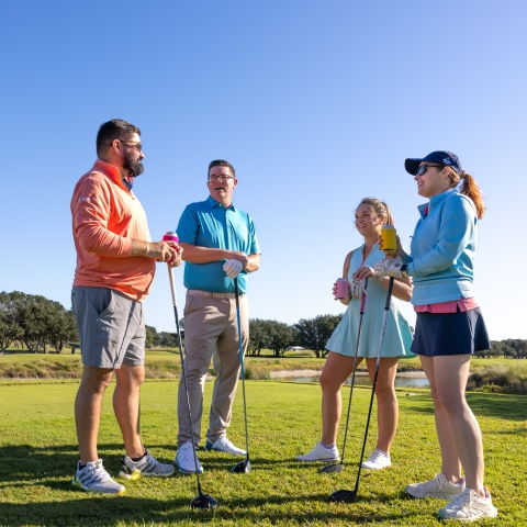 Friends playing golf at Kiva Dunes