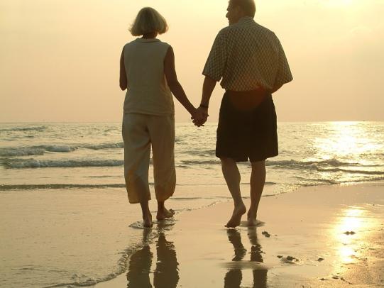 Older couple walking along Orange beach