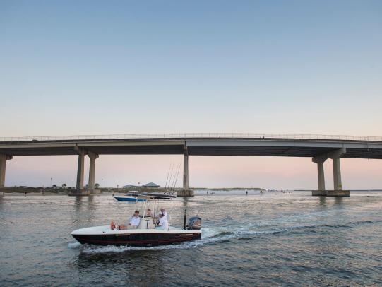 Boaters in the water near Perdido Pass Bridge in Orange Beach, best boating spots in Orange Beach