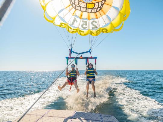 Couple parasailing over the Gulf from a boat in Orange Beach