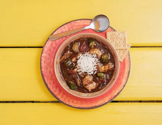 Bowl of gumbo on a yellow picnic table
