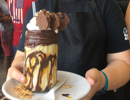 Waitress holding milkshake on plate