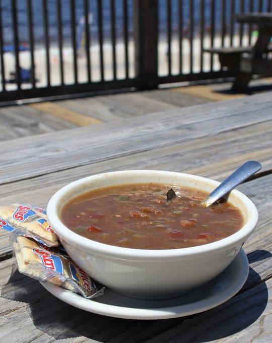 Bowl of gumbo with crackers and a view