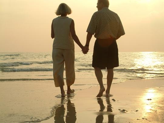 Older couple walking along Orange beach