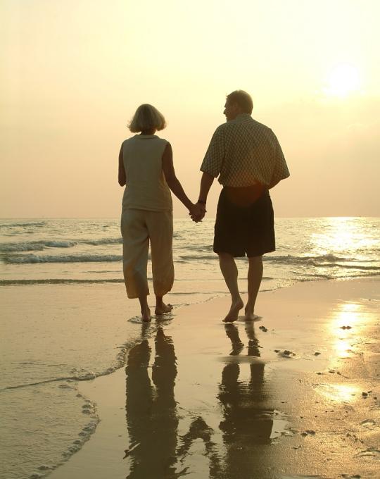 Older couple walking along Orange beach