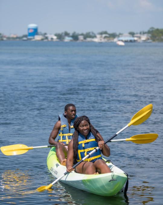 couple paddling a kayak in orange beach al