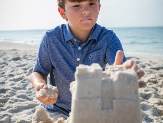 boy building a sand castle in Gulf Shores AL