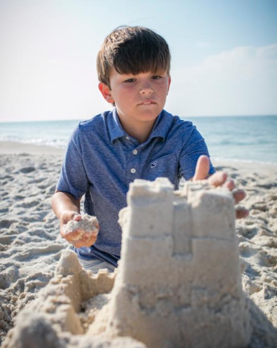 boy building a sand castle in Gulf Shores AL