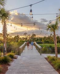 Family walking on the boardwalk leading to Gulf State Park from Beach Village Resort