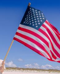 Woman holding an American flag on the beach in Orange Beach