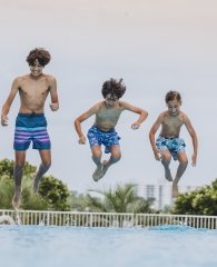 boys jumping into pool at The Caribe Resort in Orange Beach