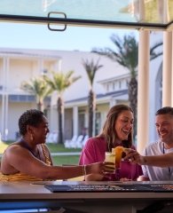 Friends drinking at the outside bar at Tee Off at The Wharf in Orange Beach
