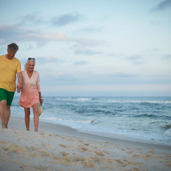 Older couple walking along Orange Beach