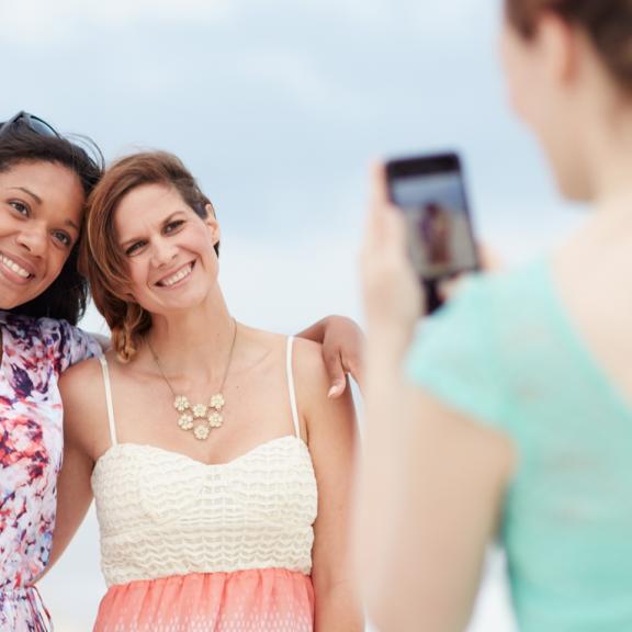 Girlfriends take photos on the beach