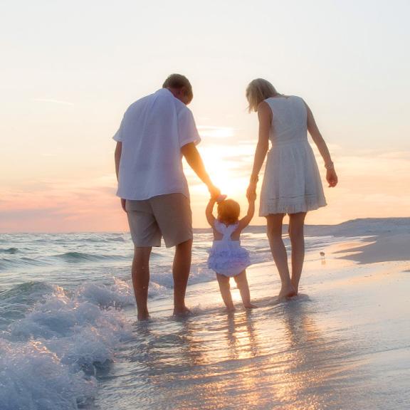 Family walking on Alabama's beaches at sunset