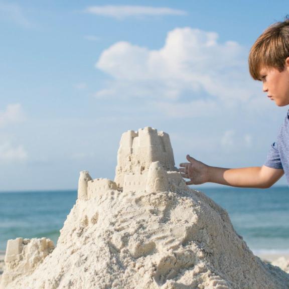 Young boy building sandcastle in Orange Beach, AL