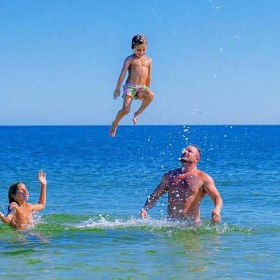 Family in the water in Orange Beach, AL