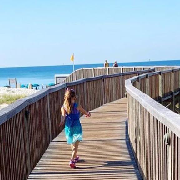 Little girl running out to the beach in Gulf Shores, AL