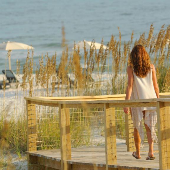 woman on boardwalk leading to beach in gulf shores and orange beach 