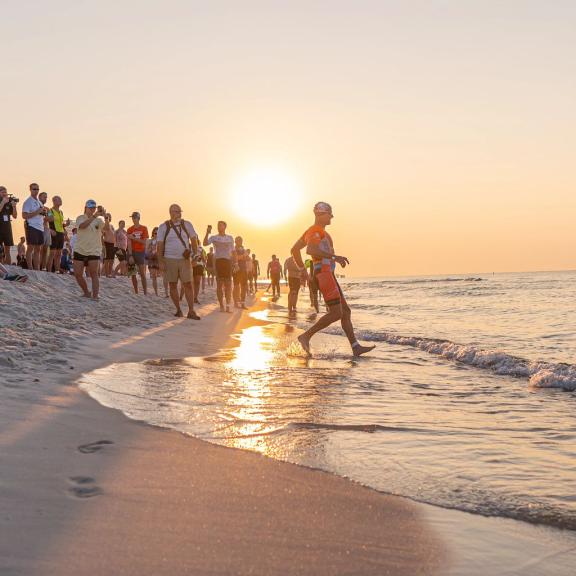 Athlete running into the Gulf during the Brett/Robinson Triathlon
