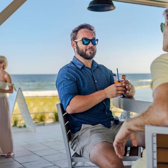 People sitting at the bar at Coastal Orange Beach beachfront restaurant