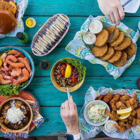Blue picnic table filled with delicious food at LuLu's waterfront restaurant in Gulf Shores
