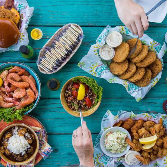 An overhead shot of a turquoise picnic table filled with seafood from LuLu's restaurant in Gulf Shores