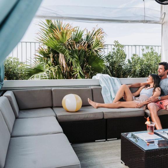 Couple lounging in a private cabana by the pool at The Caribe Resort in Orange beach
