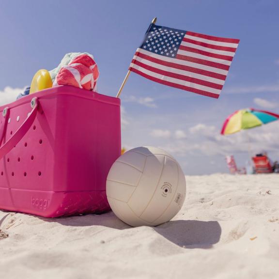 Beach bag with American flag sitting in the sand