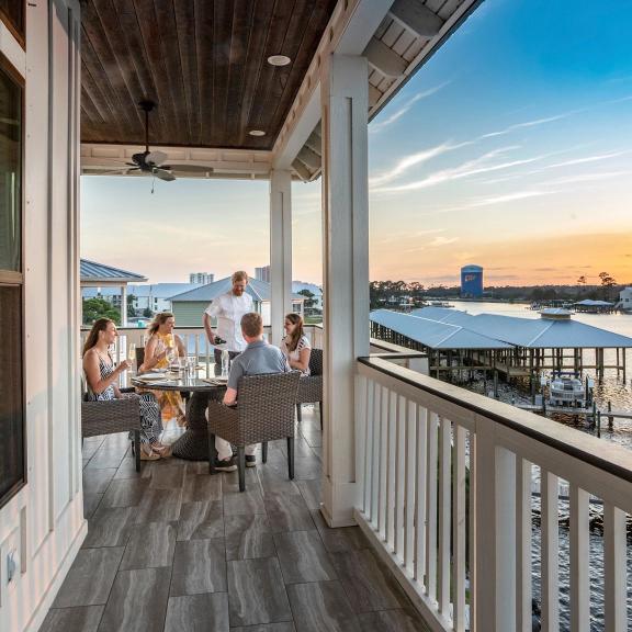 Family dining on the balcony of a waterfront beach rental in Orange Beach