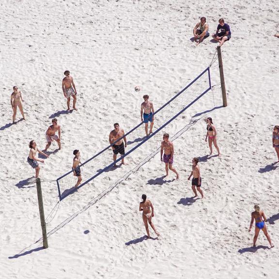 People playing beach volleyball along the shore in Orange Beach