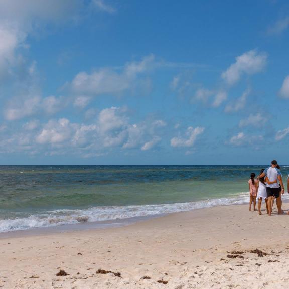 Family walking along the shoreline of the beach in Gulf Shores