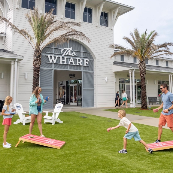 Family playing cornhole at Portisde at The Wharf in Orange Beach