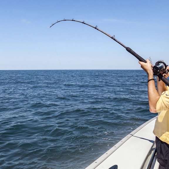 Man offshore fishing on a charter boat in Orange Beach