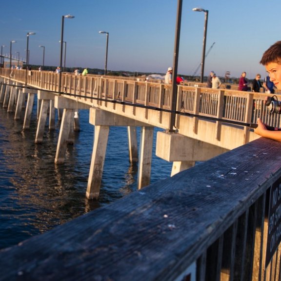 Boy fishing off the Gulf State Park Pier into the Gulf