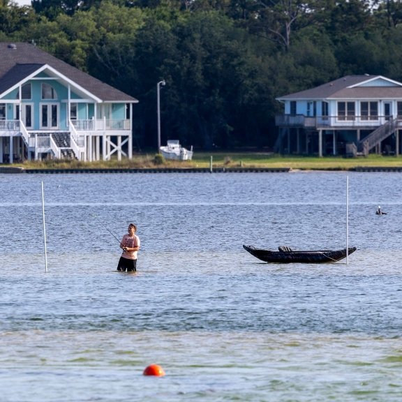 angler wade fishing in little lagoon in gulf shores