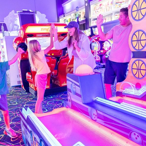 Family playing in the arcade at The Track go-kart attraction in Gulf Shores