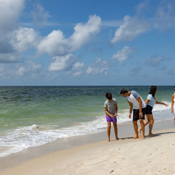 Family walking along the shoreline in Gulf Shores