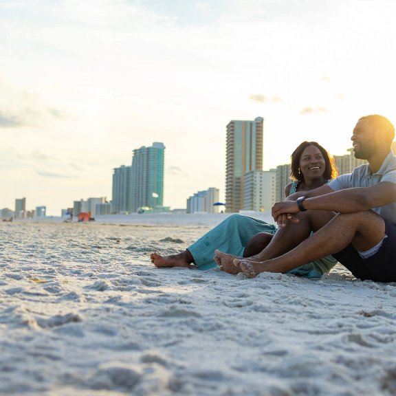 Couple relaxing on the beach watching the sunset in Orange Beach
