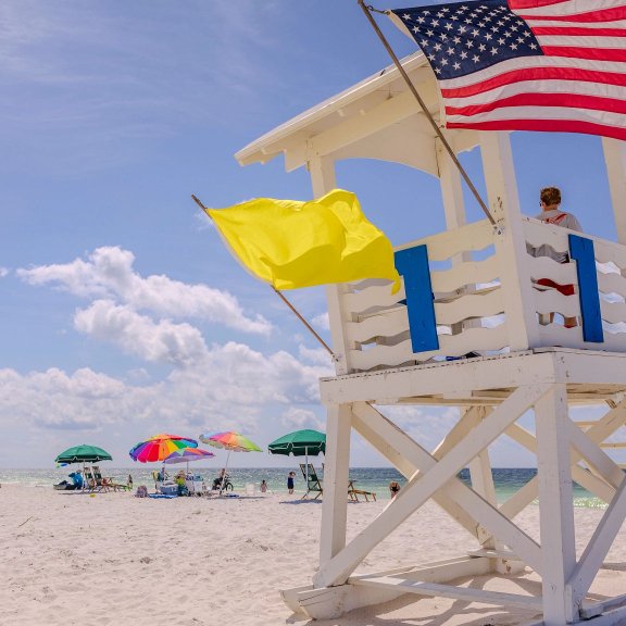 Lifeguard stand with beach safety flag at Gulf Shores public beach